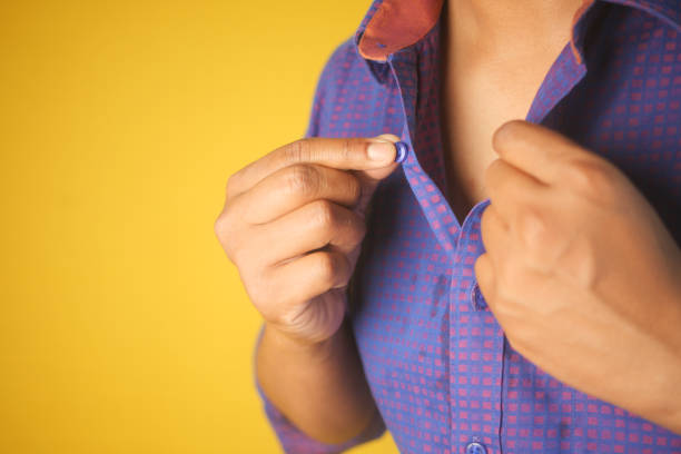 istock Man buttoning his shirt close up 2151749723