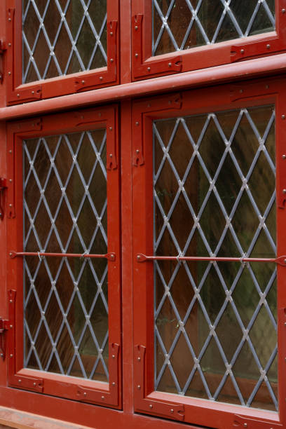 Red wooden window with iron lattice, close-up, background
