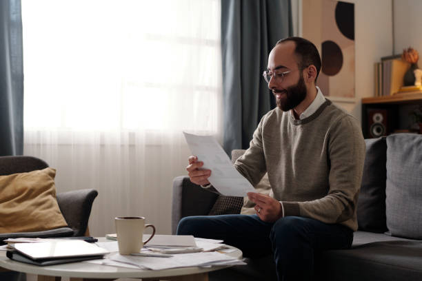 istock Happy man looking through financial bill 2151751930