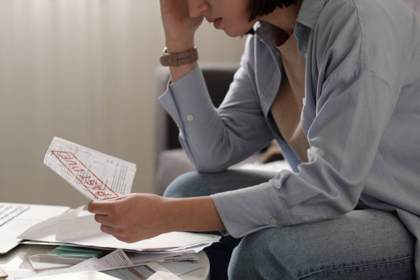 istock Young woman with past due bill in hand 2151751938