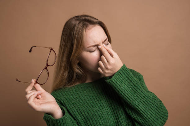 istock woman with poor vision on a isolated beige background, health problems astigmatism myopia 2151752531
