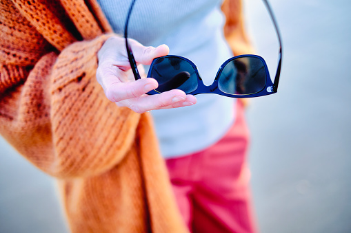 Young mature woman and sunglasses detail outdoor in a beach. Berria beach, Cantabria, Spain, Europe.