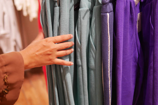 istock woman choosing clothes in shop. 2151756612