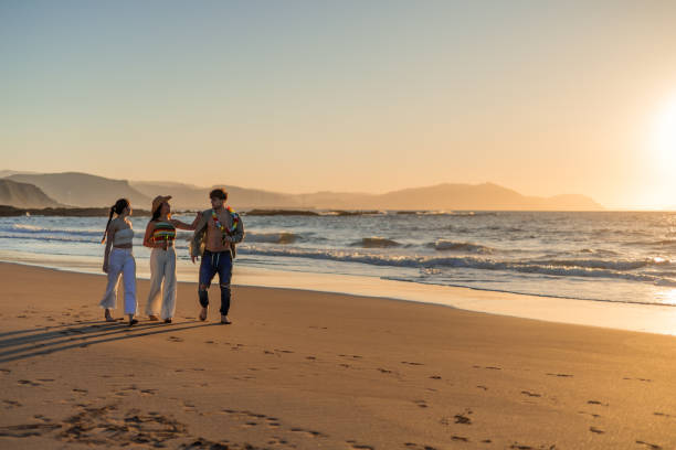 istock copyspace Three hispanic friends enjoy a leisurely stroll at sunset on the beach 2151765634