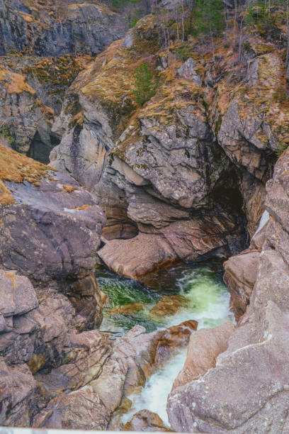 A mountain range with a river running through it. The water is clear and the rocks are grey