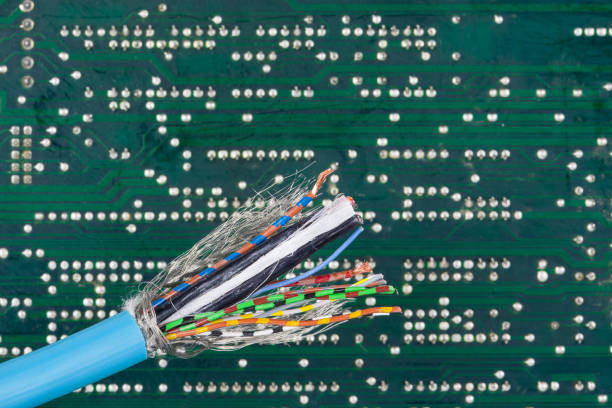 An stripped cable reveals several colored wires against a circuit board background. Clear connections for precise electronics installations.
