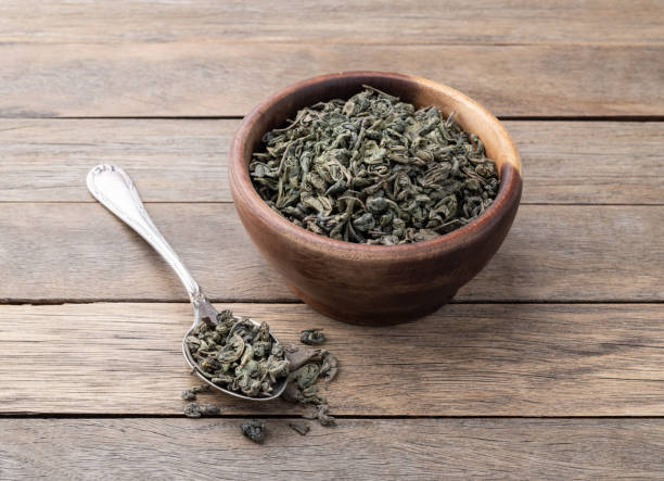 istock Dried green tea leaves on a bowl over wooden table 2151768363