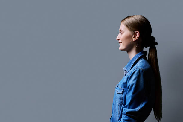 istock Profile view, young smiling female looking forward on gray studio background 2151771498