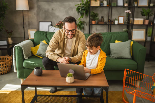 istock Father and son use lap top for homework or browse internet at home 2151774117