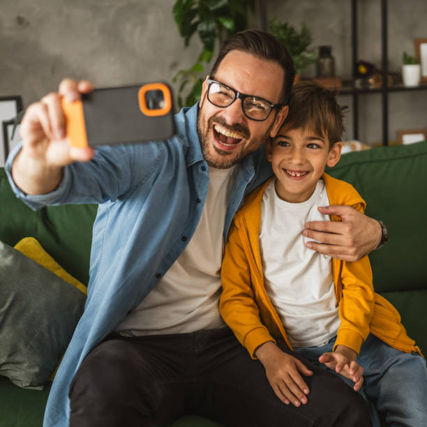 istock Father and son make a self portrait at living room 2151774527