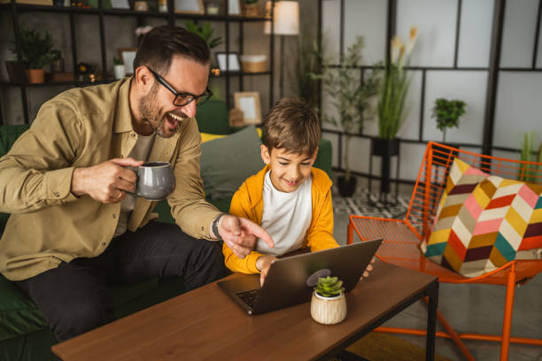 istock Father with coffee and son use laptop for homework or browse internet 2151775635