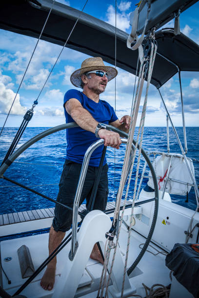 istock A man wearing a straw hat is driving a sailboat and enjoying it. 2151777070