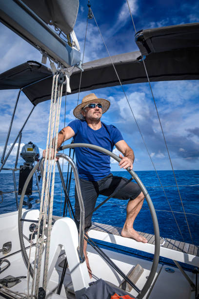 istock A man wearing a straw hat is driving a sailboat and enjoying it. 2151777106