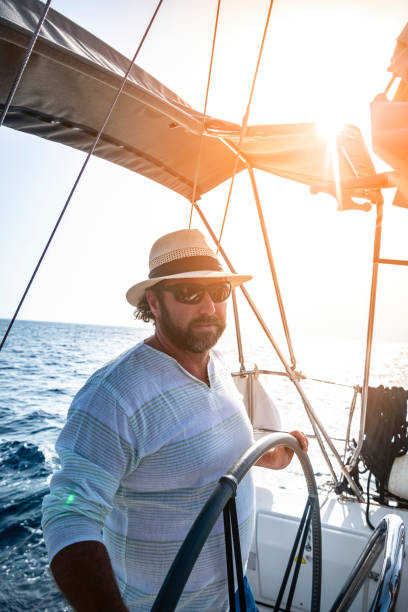 istock A man wearing a straw hat is driving a sailboat and enjoying it. 2151777126