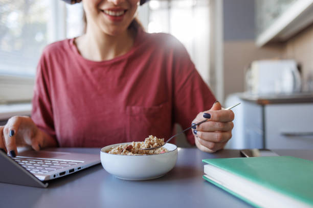 istock Woman eating cereals and using a laptop 2151777569