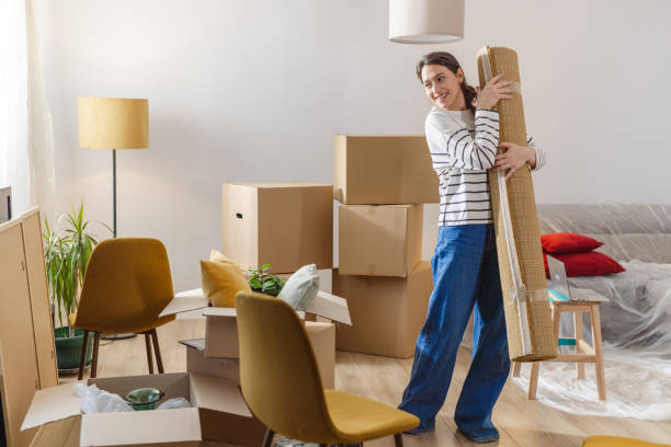 istock Young woman carrying carpet while moving house 2151790857