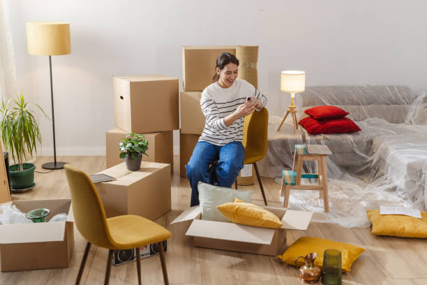 istock Young woman using smart phone in her new apartment 2151790983