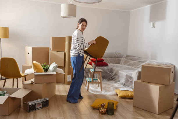 istock Smiling young woman surrounded by boxes while moving, unpacking personal belongings 2151791616