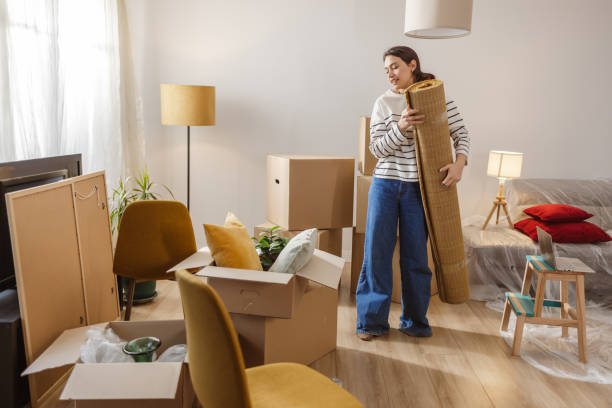 istock Young woman carrying carpet while moving house 2151791695