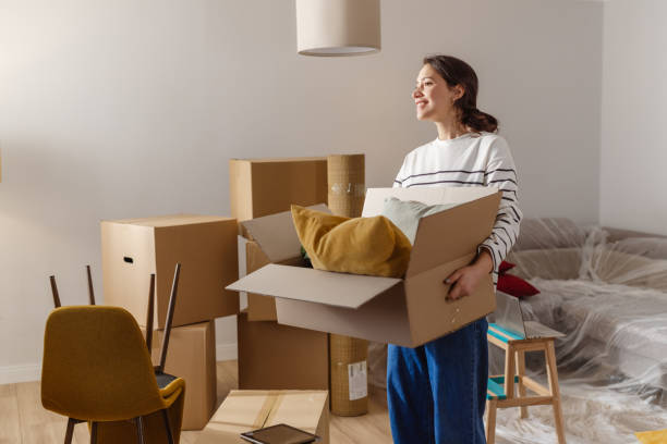 istock Young woman carrying box while moving house 2151792601