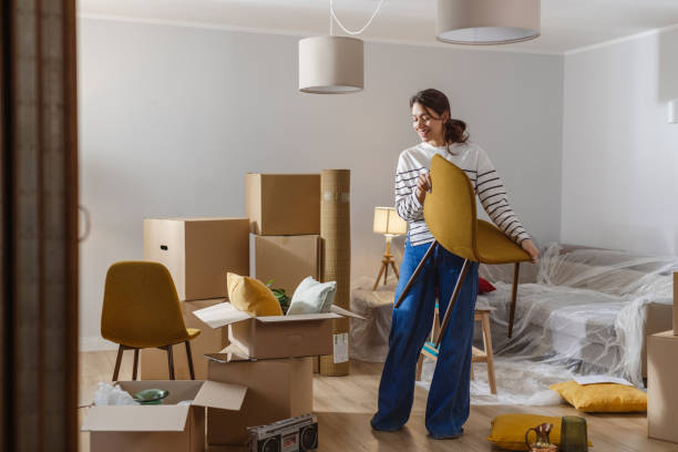 istock Smiling young woman surrounded by boxes while moving, unpacking personal belongings 2151792655