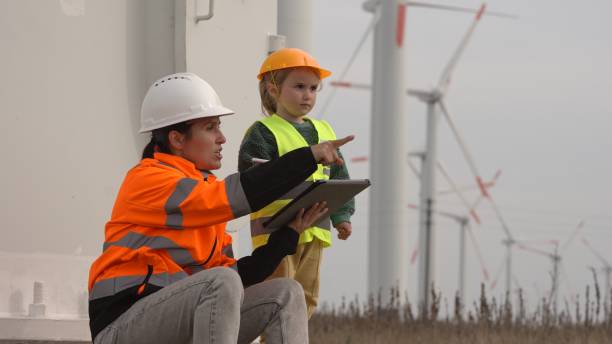 istock Green energy. Engineer Mom with Kid in Wind Farm. 2151794971