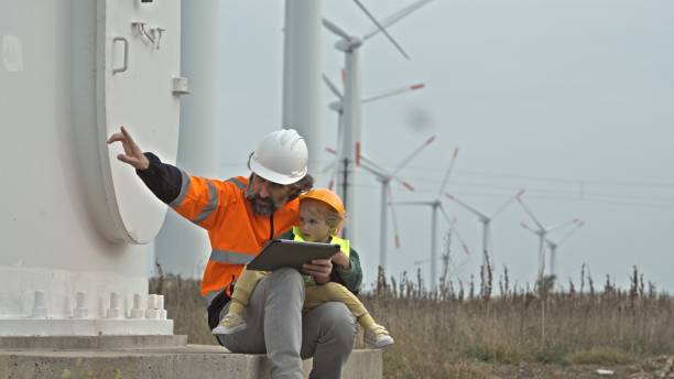 istock Green energy. Engineer Dad with Kid in Wind Farm. 2151794975
