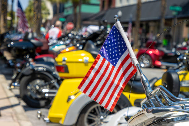 An American flag hanging on the back of a motorcycle at a rally.
