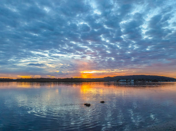 istock Sunrise over the bay water with clouds and reflections 2151798975