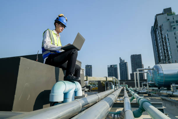 istock Site engineer with laptop communicating on construction site against a backdrop of the urban skyline. 2151799753