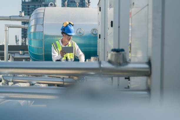 istock Technical professional evaluating air conditioning units on top of an urban high-rise. 2151802326