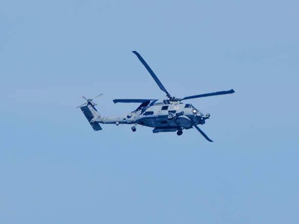 Solana Beach, California, USA- April 17, 2024: US Navy helicopter flying in a bright blue sky