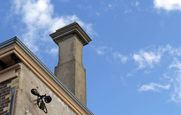 Chimney on an old building against a blue sky with scattered clouds