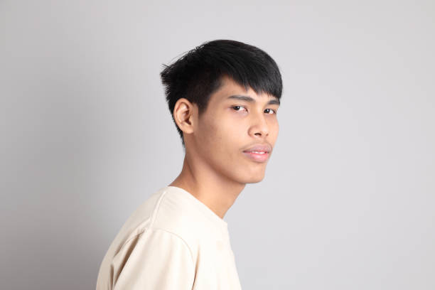 The Young South Asian teen with the casual clothes standing on the gray background. portrait, close up