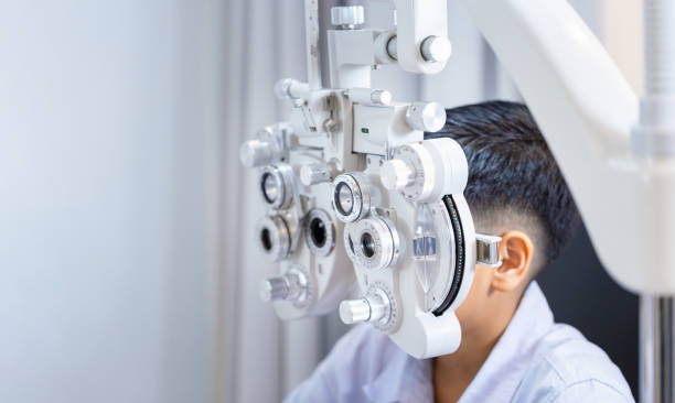 istock Boy doing eye test checking examination with an optometrist in the optical shop, Kid at the optical store 2151832917