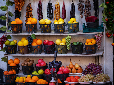 fresh fruits and traditional Georgian Churchkhela, each item meticulously placed to showcase its vibrant color and form. This image highlights the visual appeal and cultural significance of market stalls in Georgia