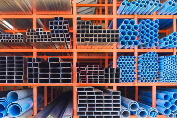 istock Various sizes of many carbon steel rectangular and square tubes with blue PVC water pipes on storage shelf of building supply store 2151835865