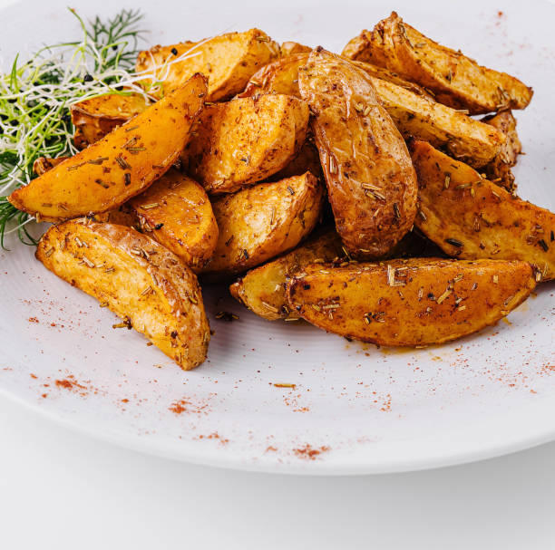istock Spicy roasted potato wedges on white plate 2151836396