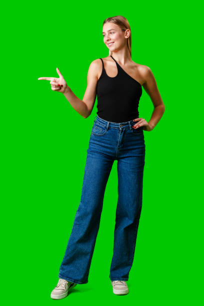 istock Young Woman Pointing at Something against green background 2151836670