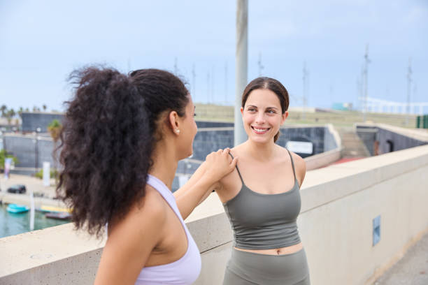istock Sporty women friends doing a leg stretching exercise while exercising outdoors on a sunny day 2151836878