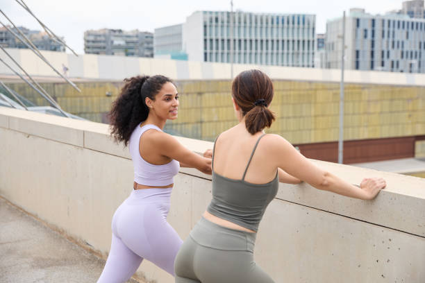 istock Two sports friends doing a stretching routine outdoors in an urban setting 2151837040