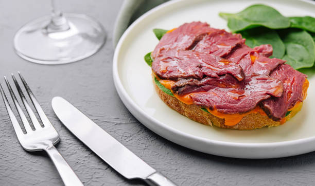 istock Gourmet beef tenderloin on toast with spinach 2151838307