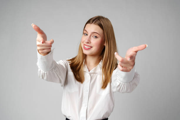 istock Young Woman in White Shirt Gesturing Come Here With Both Hands 2151841130