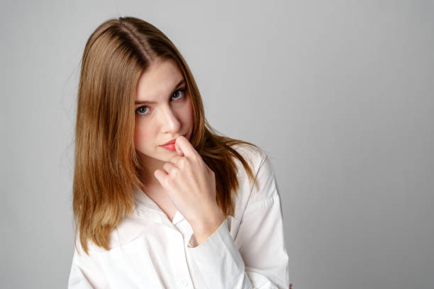 Concerned Young Woman deep in thought or contemplation on gray background