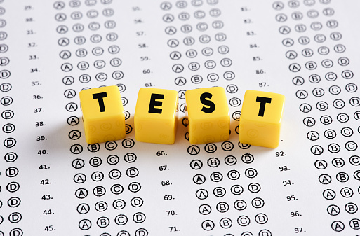 Exam paper with the word Test written on yellow cubes. Education, exam, quiz and school success concepts.