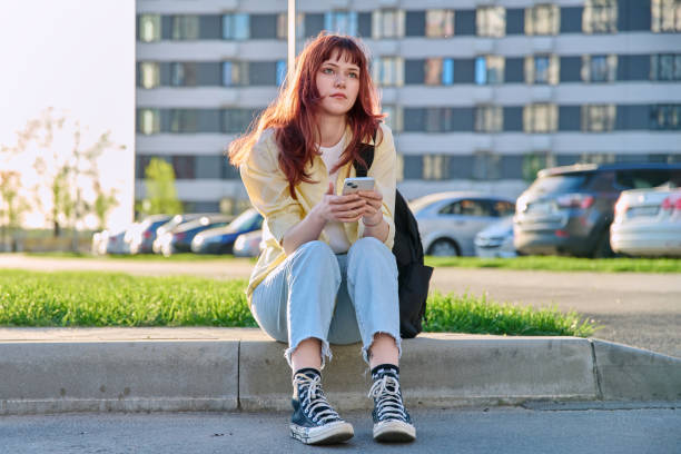 istock Young beautiful serious woman using smartphone, sitting on floor, urban style 2151843528