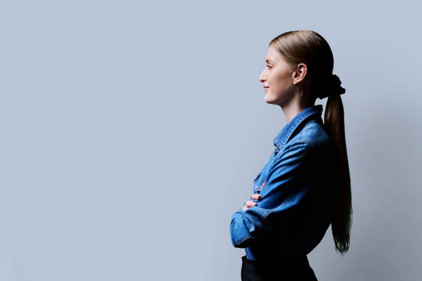 istock Profile view, young smiling female looking forward on gray studio background 2151843819
