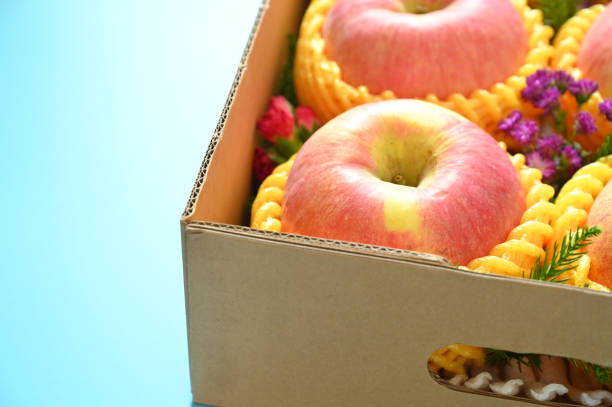 istock beautiful pink apple in the box on blue background 2151847572