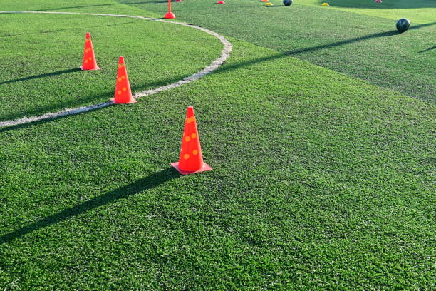 istock artificial green grass soccer field with orange training cones 2151849072