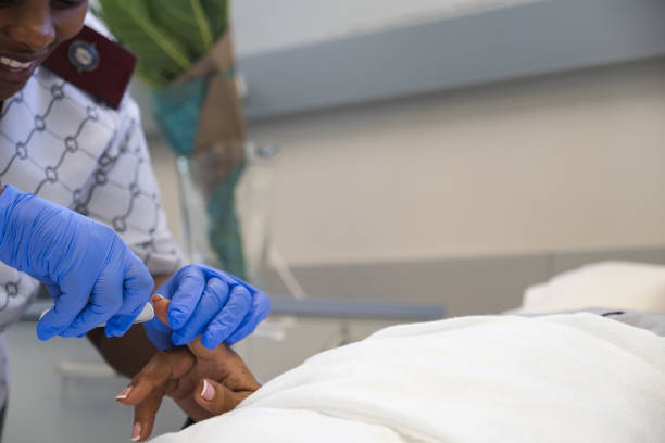 istock Nursing sister testing the patients blood sugar levels. 2151849322